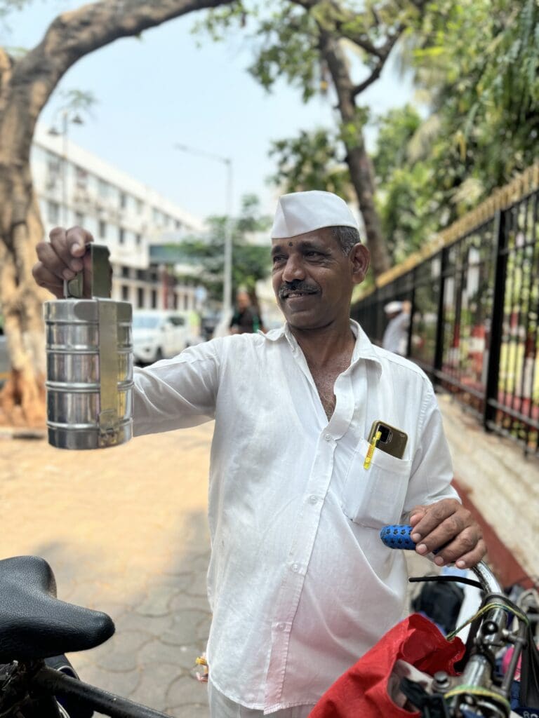 Look this up: The Dabbawalas of Mumbai or "tiffin carriers," a network of delivery personnel who specialize in transporting home-cooked meals from customers' homes to their workplaces and back again.